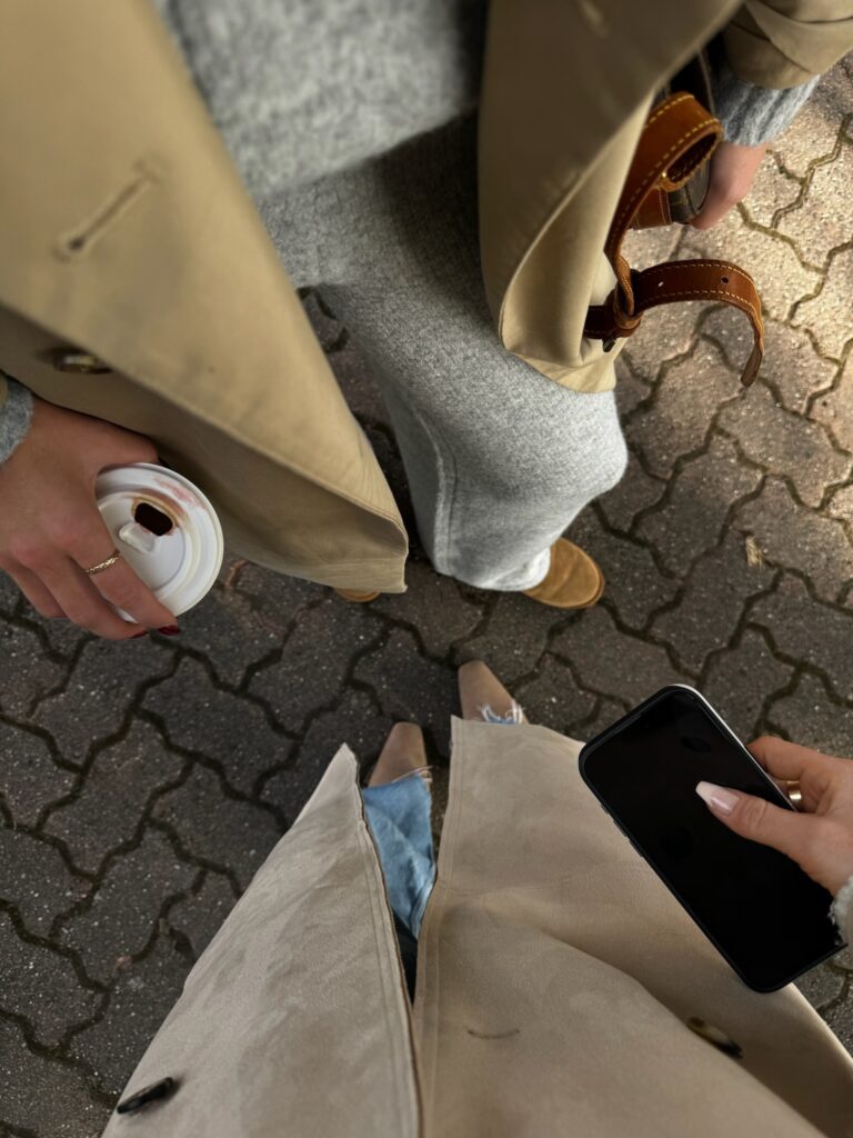 Two females speaking closely outside; photo shot down toward their feet