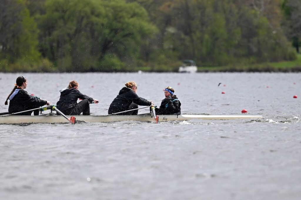 Three teenage girls on the water, racing in a regatta.